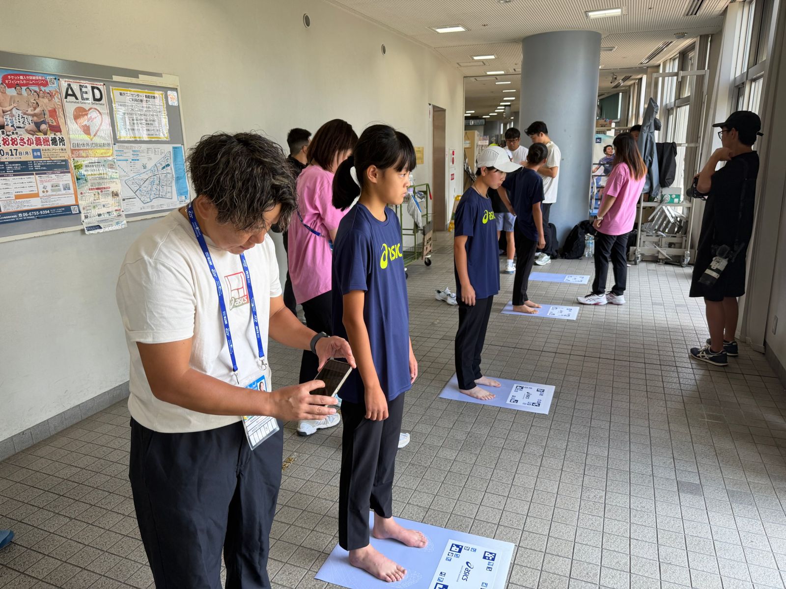 アシックスの足形測定を受けるジュニア